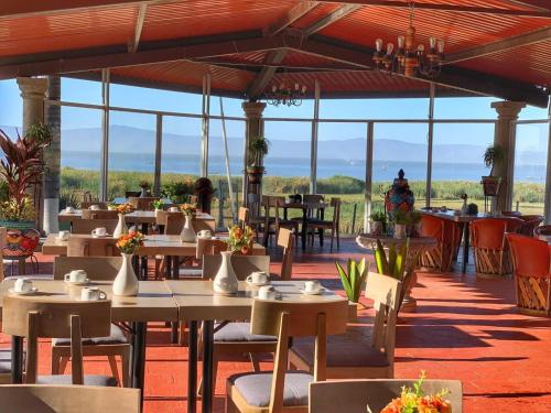 un restaurant avec des tables, des chaises et des fenêtres dans l'établissement Hotel y Restaurant Puesta del Sol, à Ocotlán
