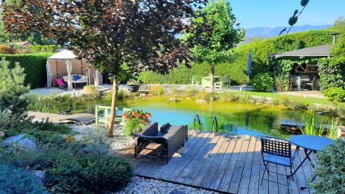 a patio with a pond with a table and chairs at Garden Paradise Bled Apartments - garden, pond and castle view in Bled