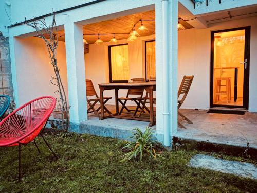 une terrasse avec une table et des chaises dans une maison dans l'établissement Dépendance Cosy dans Maison Bordelaise à 200m du tram et du CHU, à Bordeaux