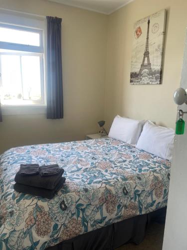1 dormitorio con 1 cama con la torre Eiffel en Coastal Accommodation en Oamaru