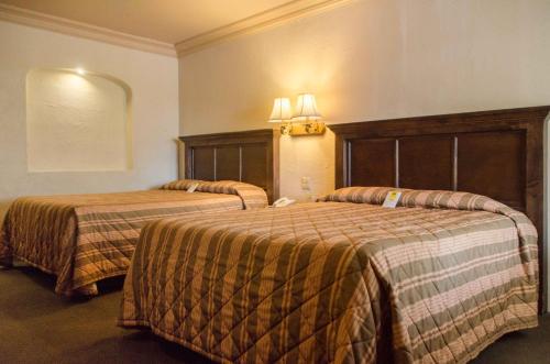 ein Hotelzimmer mit 2 Betten in einem Zimmer in der Unterkunft Hotel Siesta Real in Mexicali