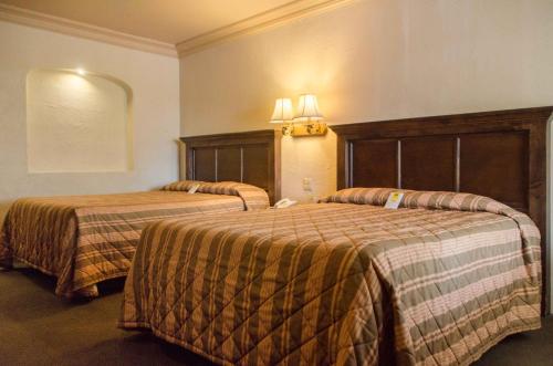 a hotel room with two beds in a room at Hotel Siesta Real in Mexicali