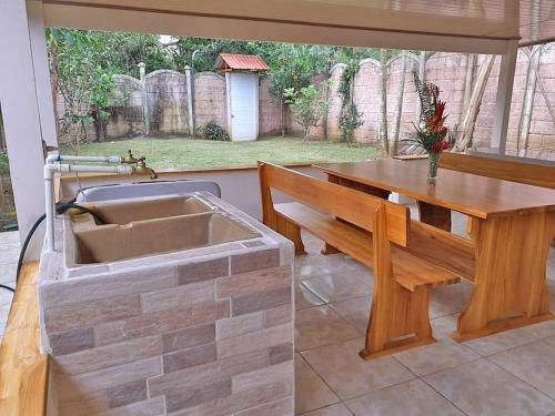 eine Küche mit einem Waschbecken und einer Holzbank in der Unterkunft Tropical Bee Garden Holiday Houses in Savegre