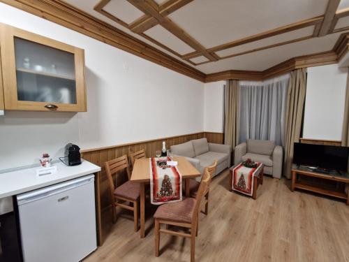 cocina y sala de estar con mesa y sillas en Pirin Golf Private Apartments & Studios en Razlog