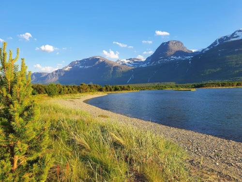 un bacino d’acqua con montagne sullo sfondo di Strandbu Camping a Skibotn