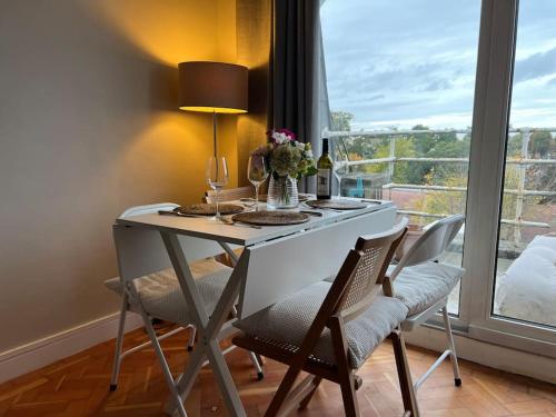 a dining room table with two chairs and a window at Richmond-On-Thames, London, Luxery Apparment With Balcony in Richmond