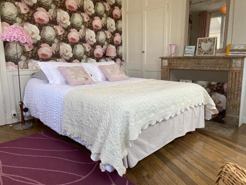 - une chambre avec un lit orné d'un mur fleuri dans l'établissement Au Jardin des Deux Ponts, à Abbeville