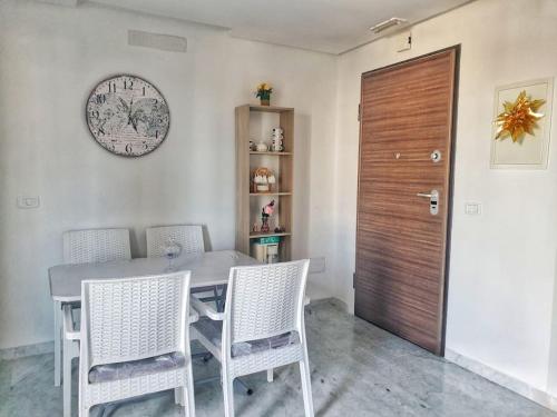 a dining room table with chairs and a clock on the wall at The jewel of the coast in Sousse