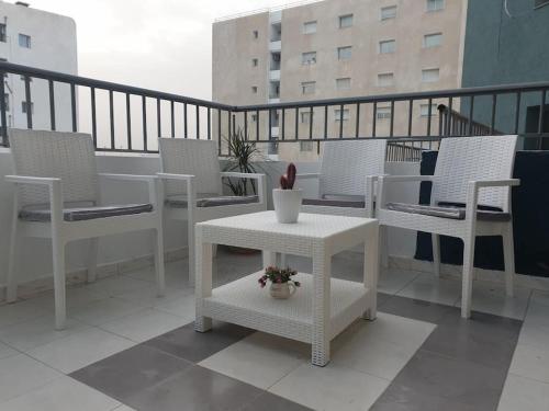 a balcony with white chairs and a table on a balcony at The jewel of the coast in Sousse