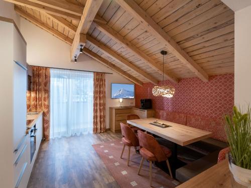 eine Küche und ein Esszimmer mit einem Holztisch und Stühlen in der Unterkunft Appartements ALMA in Mayrhofen