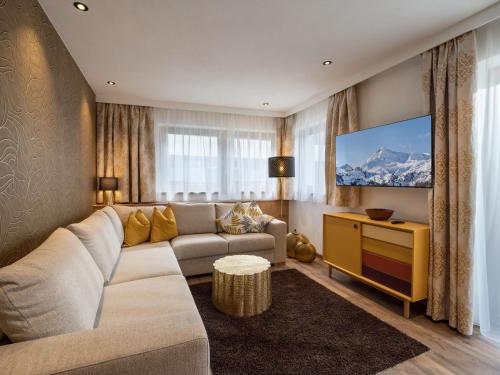 a living room with a couch and a tv at Appartements ALMA in Mayrhofen