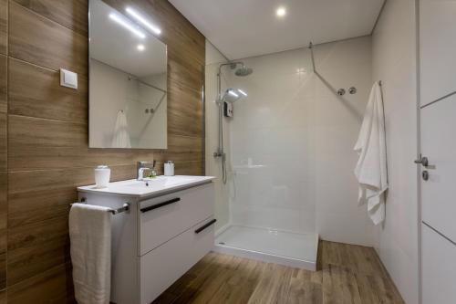 a bathroom with a white sink and a shower at Casanossa in Setúbal
