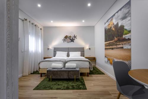 1 dormitorio con 1 cama grande y 1 mesa en Casanossa, en Setúbal