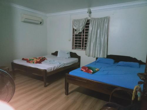 Zimmer mit 2 Betten und einem Fenster mit in der Unterkunft SunRise Villa in Kampong Cham