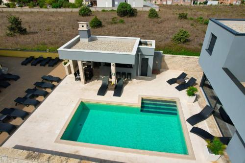 an overhead view of a swimming pool and a house at Apartments Dream House Zaton in Zaton