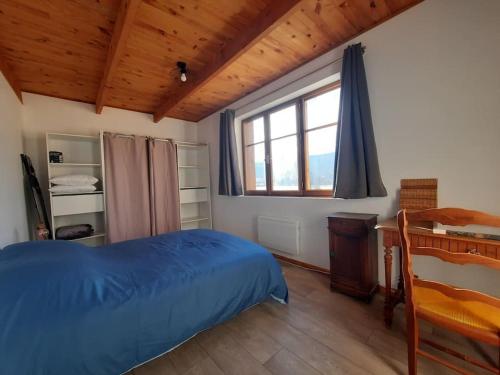 a bedroom with a bed and a desk and a window at Gîte des Millets en Baronnies in Rosans