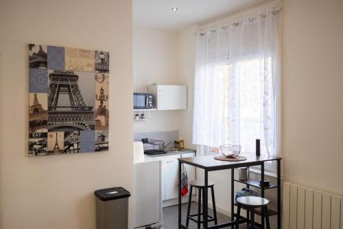 una cocina con una mesa pequeña y una ventana en T1bis Wifi 25m2 Lumineux Elégant, Roubaix Centre, en Roubaix