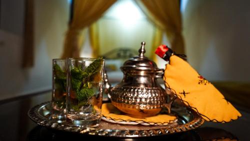 a table with a tea pot and a glass at Riad Green House in Fès