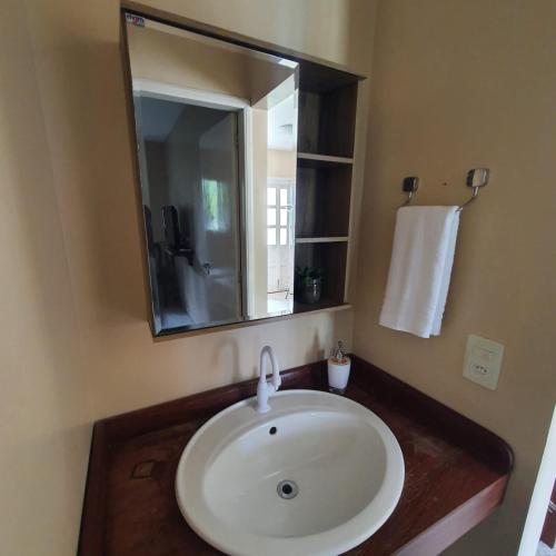 uma casa de banho com um lavatório branco e um espelho. em Casa Bouganville apto triplo em Novo Airão