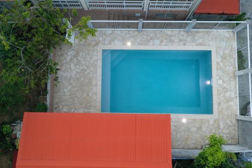 a swimming pool with a red bench in front of it at L'Oliveraie in Saint-Joseph