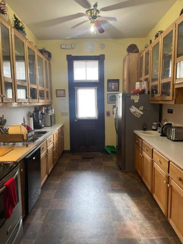 a kitchen with a black door and a refrigerator at Grand Gables Inn in Palatka