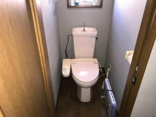 a small bathroom with a white toilet in a room at Rusutsu Risu House in Rusutsu