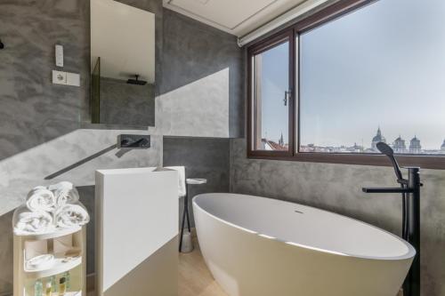 bagno con vasca e finestra di Madrid 1915 Private Suites a Madrid