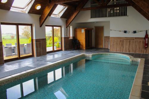 a large swimming pool in a house with at Bedw Barn in Newtown