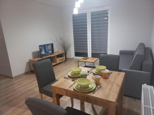 a living room with a wooden table and chairs at Apartament Rumia z Garażem in Rumia
