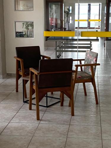 two chairs and a table in a room at Apartamento Pé na Areia in Caraguatatuba