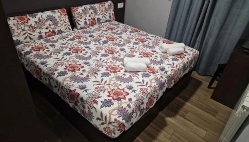 1 cama con colcha floral y 2 toallas en corazón San Bartolomé, en Madrid