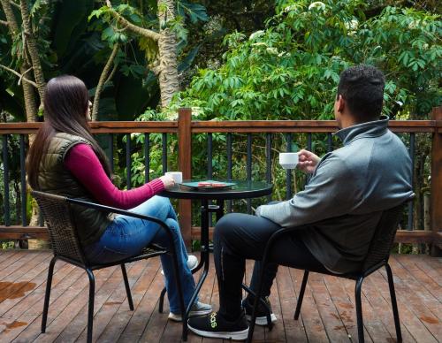 a man and a woman sitting at a table at Cabinas El Quetzal in San Gerardo de Dota
