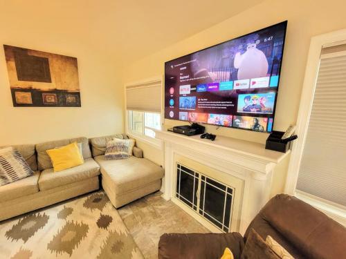 a living room with a couch and a large flat screen tv at Nice 2BDR near Airport with fast WiFi / Metro / Parking in Herndon