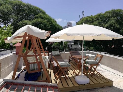 einen Tisch, Stühle und einen Regenschirm auf einer Terrasse in der Unterkunft Private Room in Beautiful Home in Montevideo