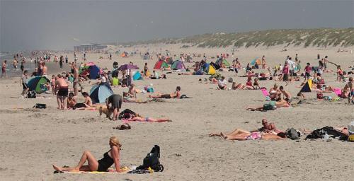 a large group of people on a beach at TIME-OUT met ZONNIG TERRAS, eigen KEUKEN, Dichtbij Dorp, Duinen, Strand en Vuurtoren , Incl verwarmd Hotel-ZWEMBAD in Hollum