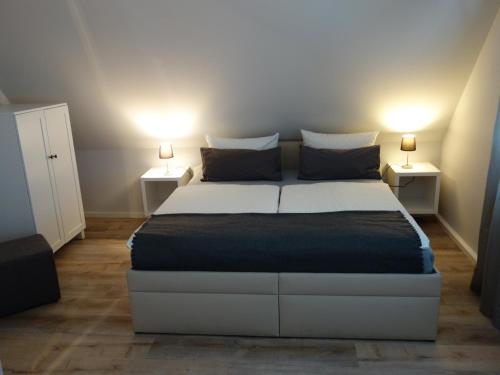 ein Schlafzimmer mit einem Bett mit zwei Lampen auf beiden Seiten in der Unterkunft Amandas Nest in Zingst
