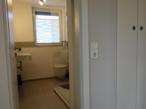 ein Badezimmer mit Waschbecken und Toilette und einem Fenster in der Unterkunft Amandas Nest in Zingst