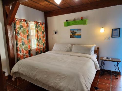 um quarto com uma cama branca e uma prateleira verde na parede em The BNB on Triggerfish Close to the airport em Ladyville
