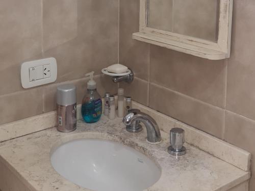 La salle de bains est pourvue d'un lavabo et d'un miroir. dans l'établissement departamentos corrientes, à Corrientes