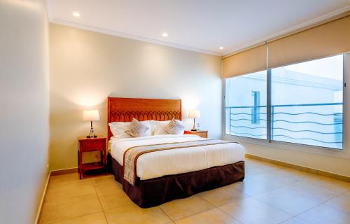 a bedroom with a bed and a large window at Indium Villas Durrat Al Arus for families only in Durat  Alarous