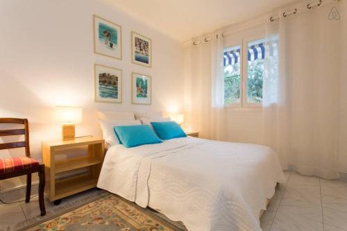 une chambre blanche avec un grand lit avec des oreillers bleus dans l'établissement Holiday or Congress, Centre - Beach, à Cannes