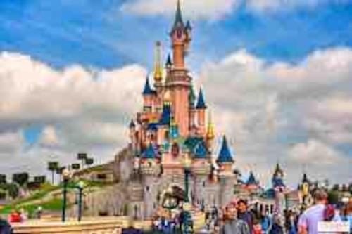 a disney castle with people standing in front of it at Petit Nid Douillet avec parking privé 