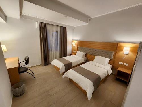 um quarto de hotel com duas camas e uma secretária em St Andrew's Guesthouse - Ramallah em Ramallah
