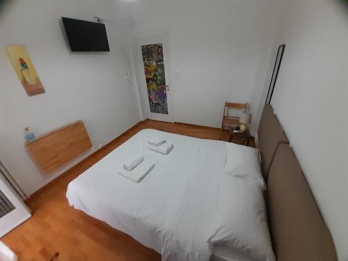 a bedroom with a white bed in a room at Central Mark-Δωμάτια Διαμερίσματος in Volos