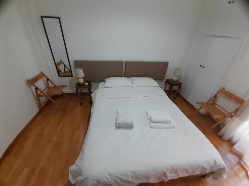 a bedroom with a large bed with two towels on it at Central Mark-Δωμάτια Διαμερίσματος in Volos