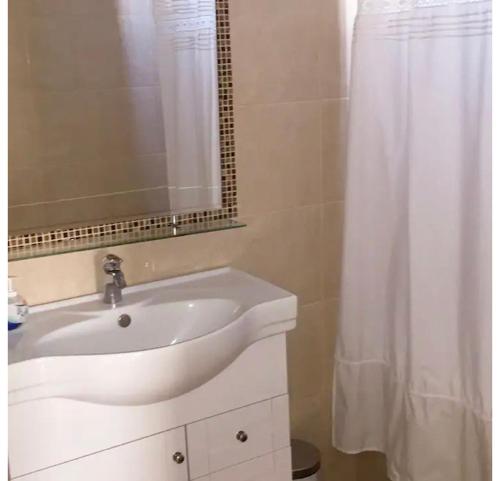 baño con lavabo blanco y cortina de ducha en Casa con Piscina privada en Pica, en Iquique