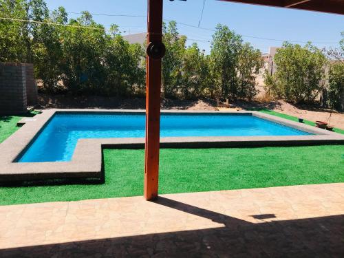 una piscina en un patio con césped verde en Casa con Piscina privada en Pica, en Iquique