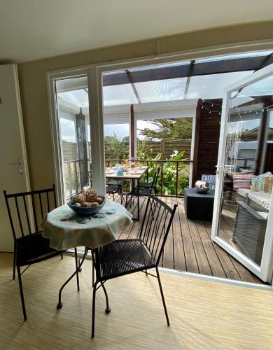 une chambre avec une table et des chaises sur une terrasse dans l'établissement Driftwood, à Erdeven