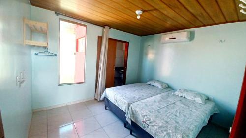 um pequeno quarto com uma cama e uma janela em Chaleville Coqueiro 3202 - Luis Correia Piauí em Luís Correia