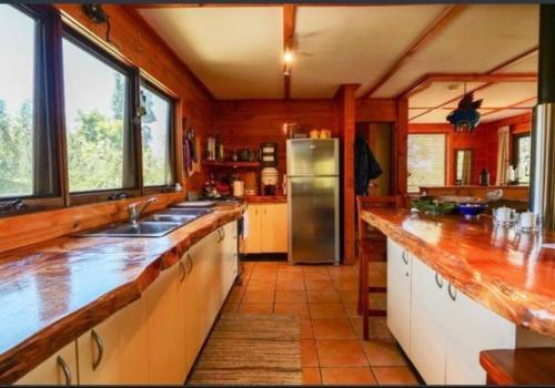 cocina grande con paredes de madera y encimeras de madera en Black Wattle Cabin Turon Escape Capertee, en Capertee